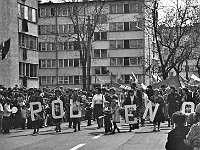 1986-1988-027  1 maja (lata 1986-1988)  Jawor, ul. Wyszyńskiego (daw. Rapackiego)  Obchody 1 maja - Święta Pracy    Uczestnicy pochodu zmierzający w kierunku trybuny honorowej.  Pracownicy Jaworskich Zakładów Chemii Gospodarczej "Pollena".