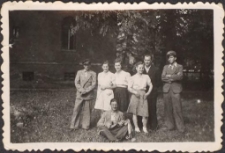 Grupowe zdjęcie rodzinne, z tyłu fragment budynku kina, lata 60. (1) [Dokument ikonograficzny]
