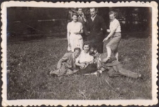 Grupowe zdjęcie rodzinne, z tyłu fragment budynku kina, lata 60. (2) [Dokument ikonograficzny]