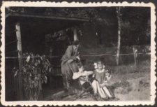 Janina Pawluk z córką Jolantą na leżaku, w tle budynek szkoły przy ul. Dworcowej 64, lata 50. XX w. [Dokument ikonograficzny]