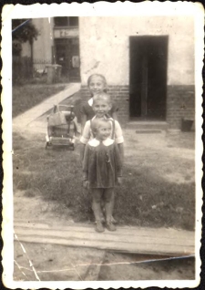 Podwórko domu przy ul. Dworcowej 62, od przodu stoją Ewa, Zbyszek i Jola Pawlukowie, ok. 1960 r. [Dokument ikonograficzny]