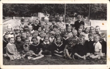 Zdjęcie na boisku szkolnym w Szkole Podstawowej nr 1 - piąty z prawej (za dziewczynką w marynarskim mundurku) Zbyszek Pawluk, ok. 1960 r. [Dokument ikonograficzny]