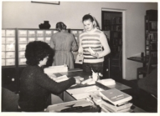 Wnętrze biblioteki publicznej w Obornikach Śląskich przy ul. Trzebnickiej 1a, Barbara Braszka podczas dyżuru w dziale dla dorosłych, 1980 r. [Dokument ikonograficzny]