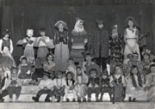 Grupowe zdjęcie dzieci, przebranych za postacie literackie i biorących udział w balu z okazji Dnia Dziecka, na schodach sceny Obornickiego Ośrodka Kultury, 1.06.1983 r. [Dokument ikonograficzny]