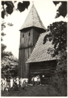 Zespoły ludowe z gminy Oborniki Śląskie przy drewnianym kościółku w skansenie na Opolszczyźnie, maj 1984 r. [Dokument ikonograficzny]