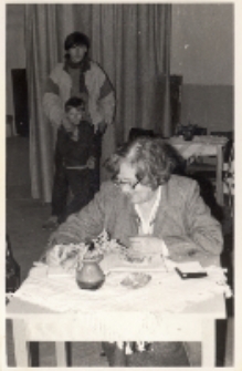 Zdjęcie red. W. Staniszewskiej z Polskiego Radia w świetlicy w Piekarach udzielającej autografu przy okazji nagrania piosenek ludowych i kolęd w wykonaniu miejscowego zespołu śpiewaczego, 11.12.1987 r. [Dokument ikonograficzny]