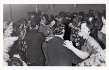 Zdjęcia sali wiejskiego ośrodka kultury w Pęgowie wypełnionej tańczącymi na zabawie sylwestrowej, widoczna serpentynowa dekoracja sufitu, 31.12.1977 r. [Dokument ikonograficzny]