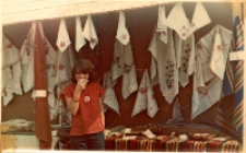 Zdjęcie straganu z serwetkami i starociami z różnych wsi gminy Oborniki Śląskie, w tym z Osoli i tamtejszego Koła Gospodyń Wiejskich, na festynie podczas eliminacji wojewódzkich Turnieju „Kolorowe Wsie”, 21.09.1980 r. [Dokument ikonograficzny]